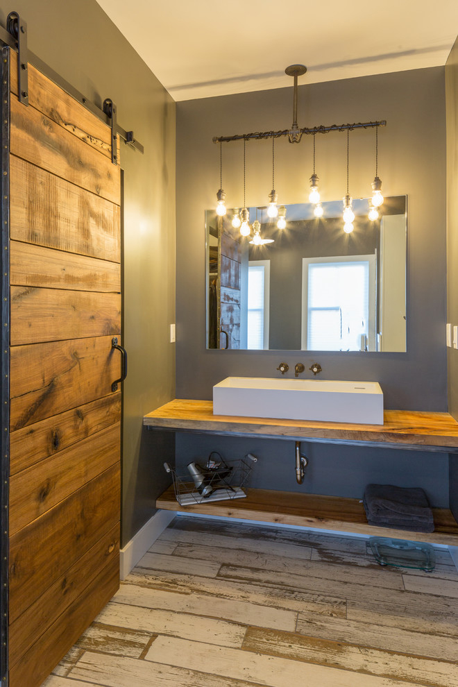 Rustic bathroom with exposed hanging bulb light fixture.