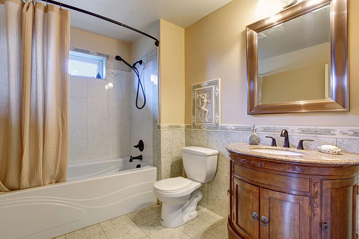 A small bathroom with a tan shower curtain.