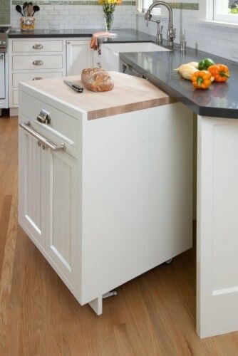 Small kitchen with moveable kitchen island that tucks away under counters.