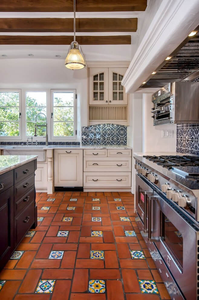 Spanish-style kitchen with terracotta flooring and a vibrant backsplash.