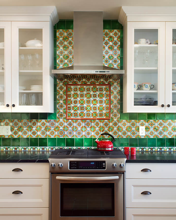 Spanish-traditional kitchen featuring a green and orange ceramic backsplash.