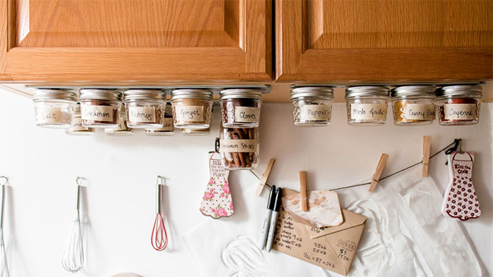Spices in mason jar mounted to magnetic strip under cabinet.