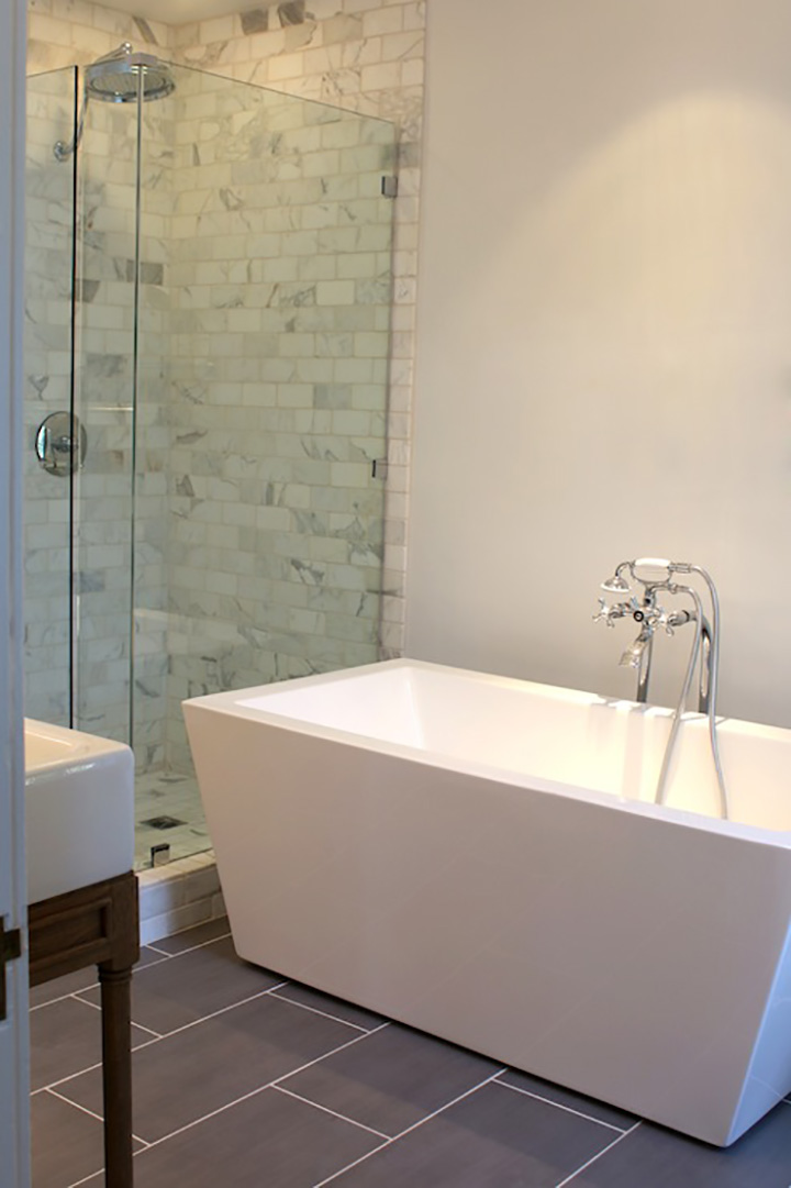 Square edge, white bathtub, gray tile floor, shower