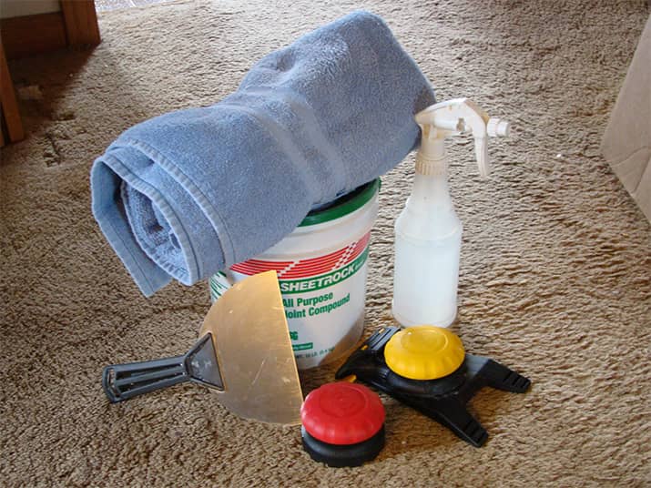 Supplies for wallpaper removal such as removal solution and scraper.
