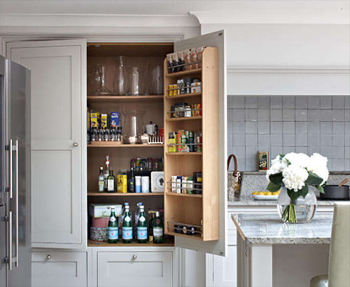 A tall cabinet pantry equipped with door shelves. This set of open doors is right above another pantry cabinet.