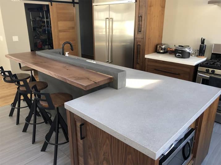 Tiered kitchen island with wood and concrete countertops.