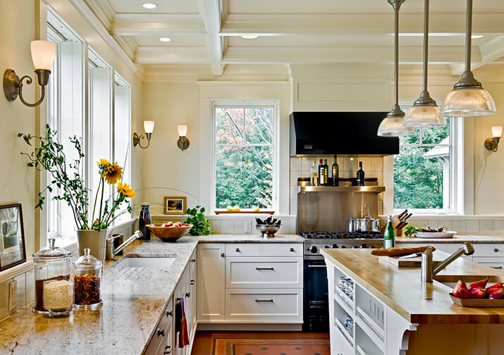 Traditional kitchen and island with recessed lighting over the countertops.