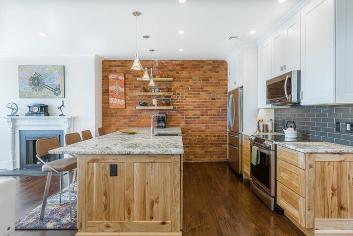 Transitional kitchen with a brick accent wall.