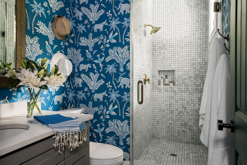 Blue wallpaper in the bathroom with a pattern of animals and plants.