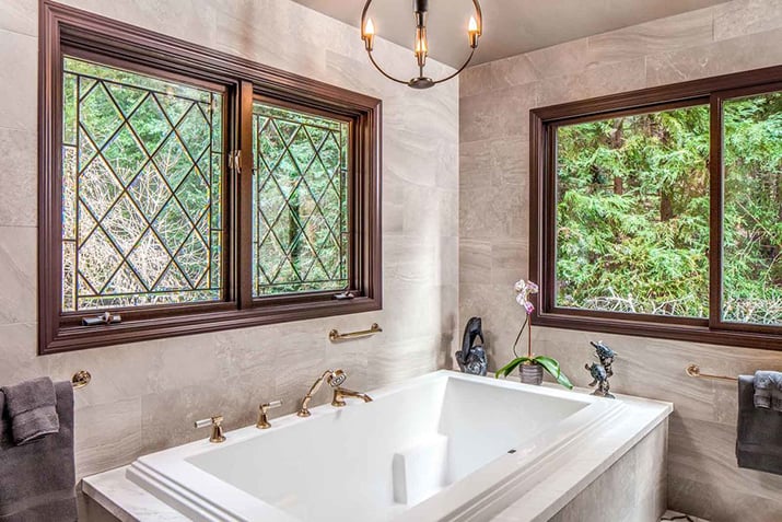 Tudor windows look out to greenery from the master bath.