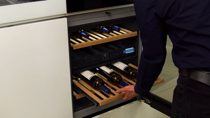 Under-cabinet wine rack keeping bottles off the kitchen counter.