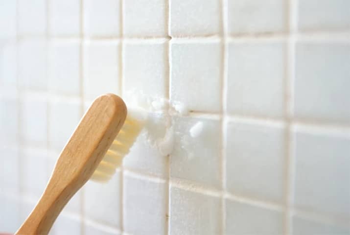 Use a toothbrush to scrub the bathroom grout with hydrogen peroxide and vinegar.
