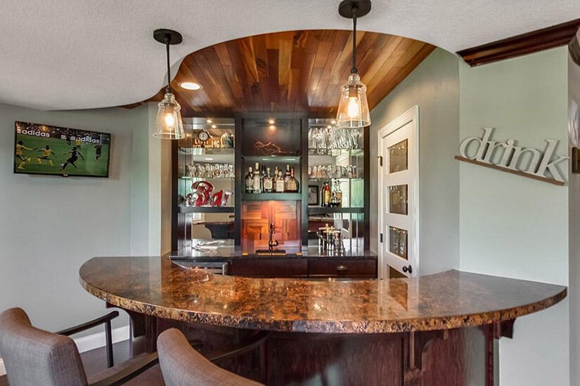 Wet bar ideas like this curved countertop bring drama to the space.