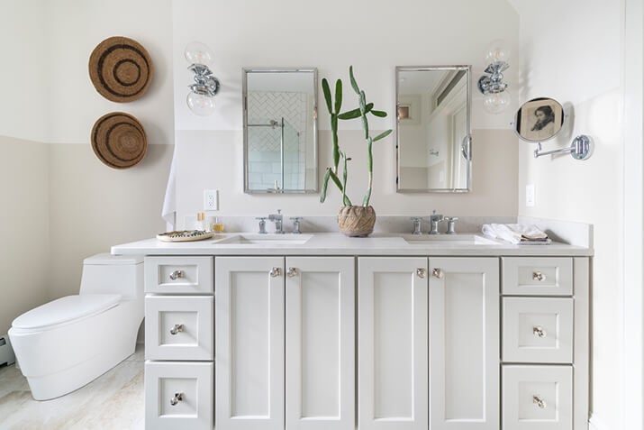 White bathroom cabinets and drawers with a double vanity.