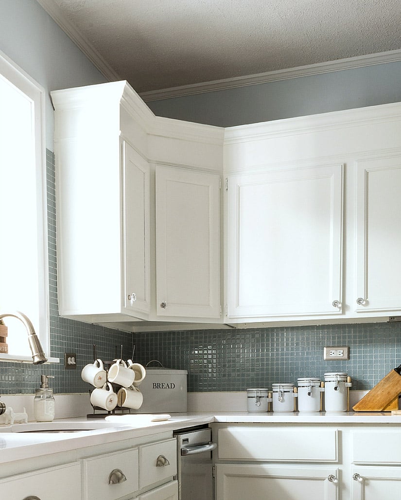 White cabinets with crown molding around a corner.