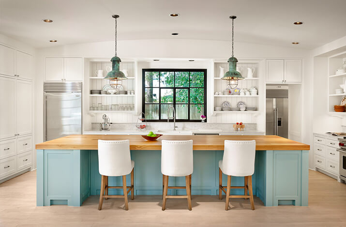 Kitchen with white cabinets and open shelving with a blue kitchen island.