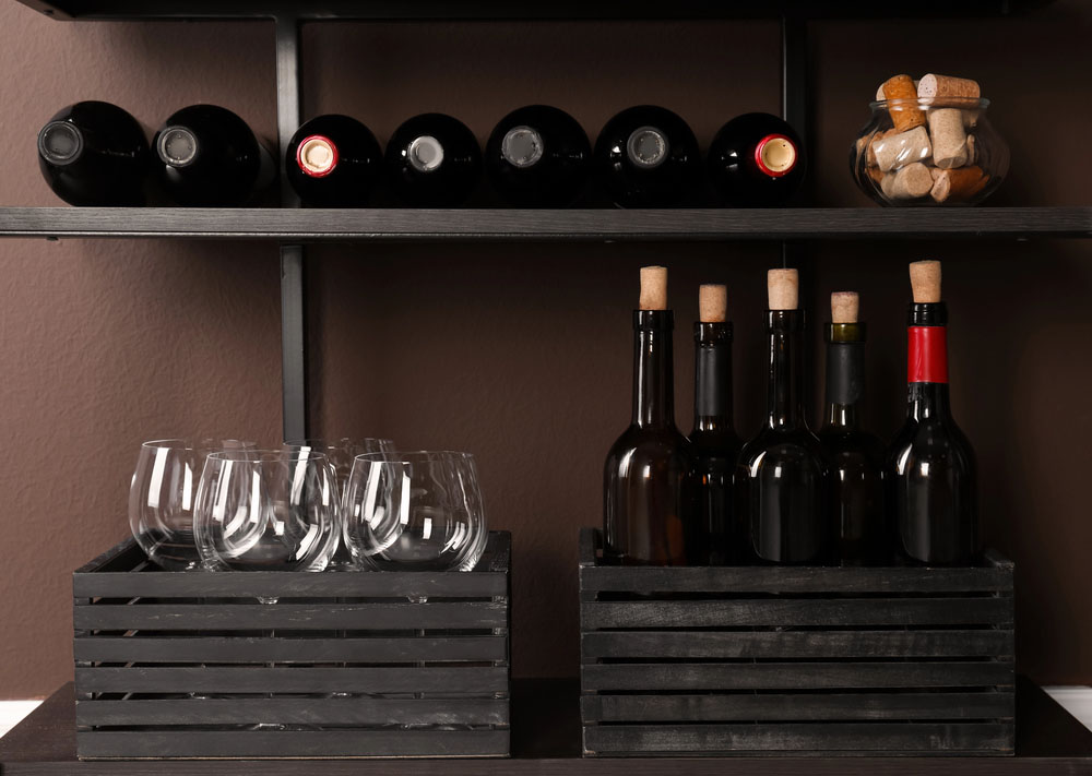 Wine bottles stored in stacked wooden crates as a unique wine rack idea.