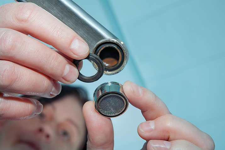 Woman installing a new faucet in her bathroom.