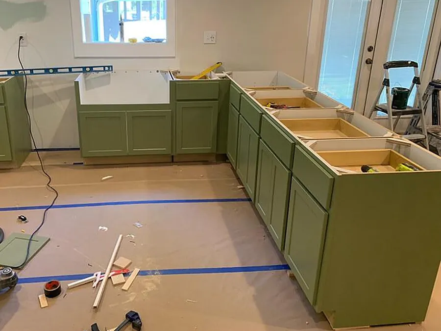 Patton Laurel green base cabinets being installed in an open kitchen
