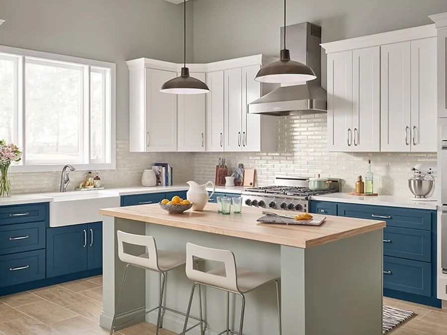 Bowery Palmetto kitchen with pale gray-green cabinets, a butcher block island and a deeper blue perimeter