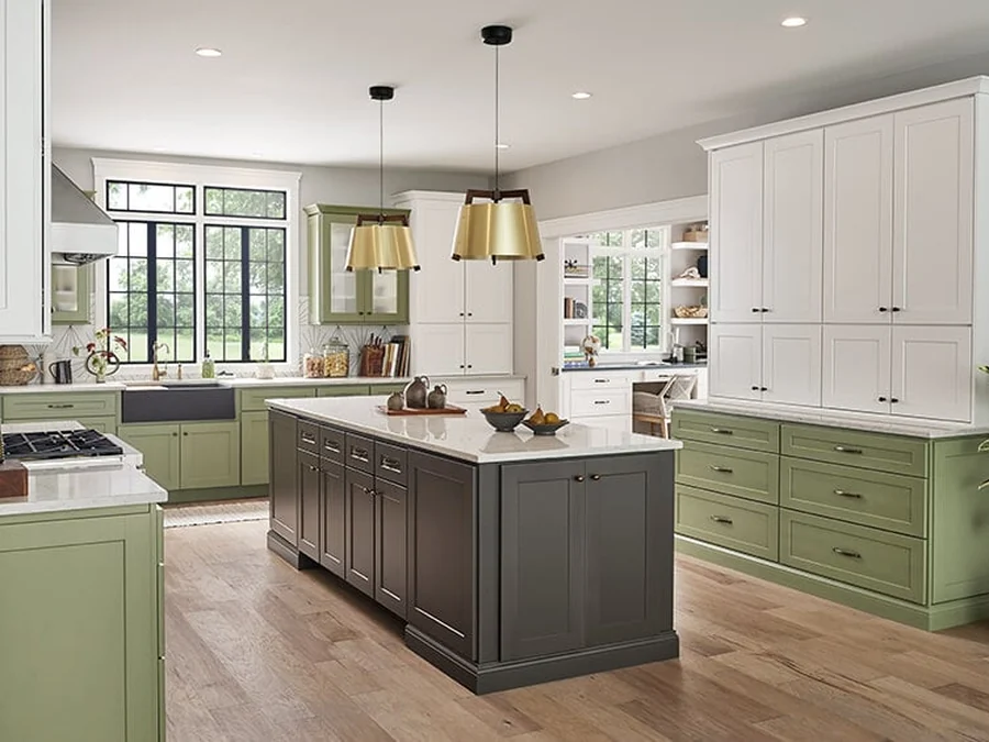 Bowery Laurel kitchen with olive green perimeter cabinets, a dark island and brass pendants