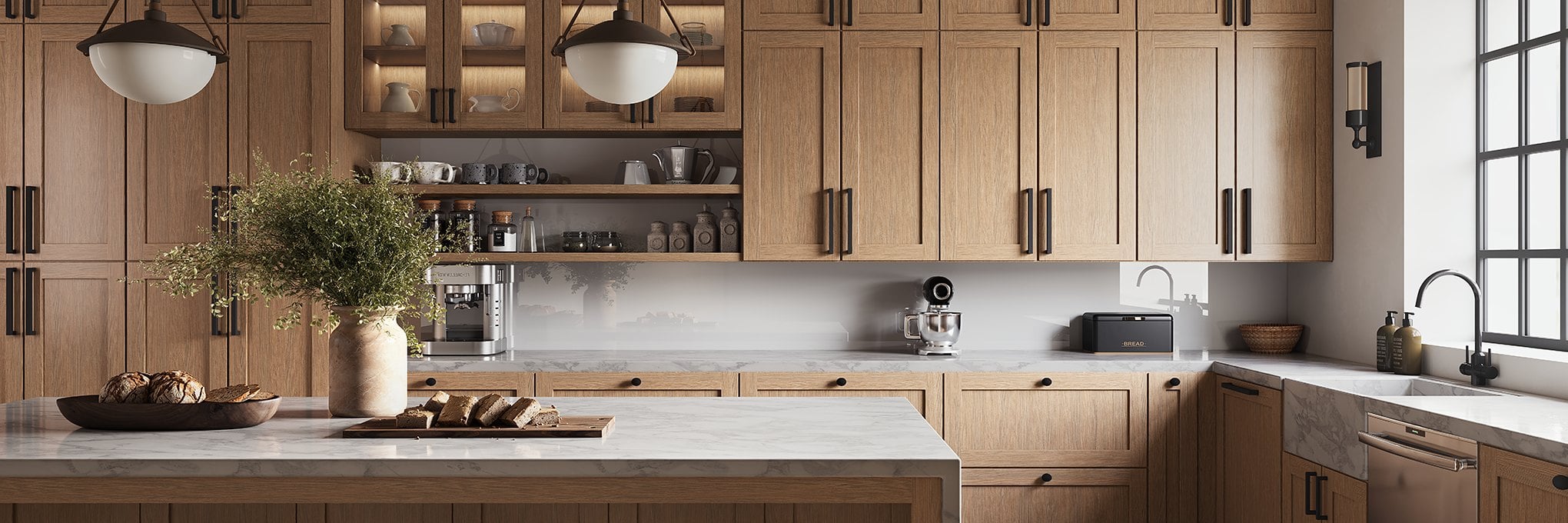 A natural oak kitchen with a marble island, glass-front uppers and black pendant lights