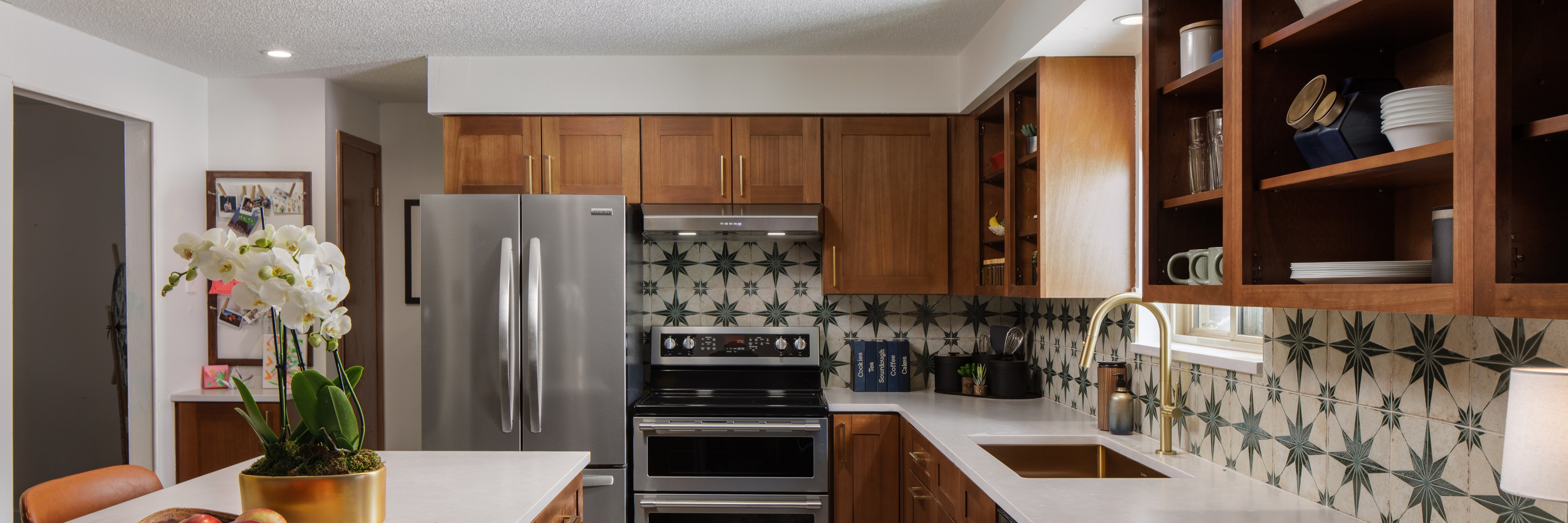 A warm wood kitchen with a patterned tile backsplash and open shelves