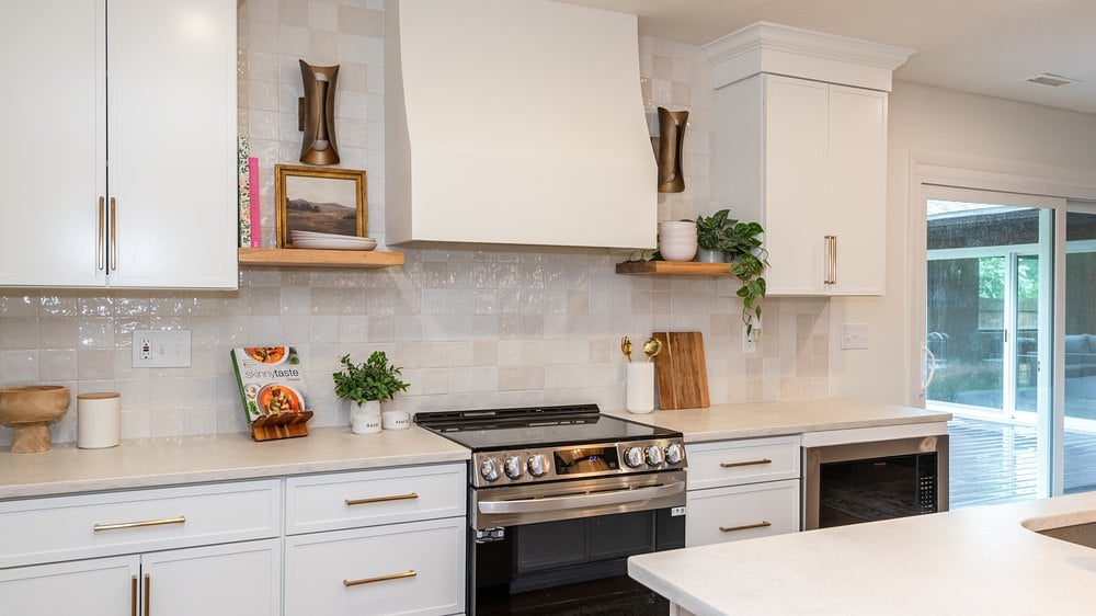 Petit White cabinets with a range, a white hood and floating shelves