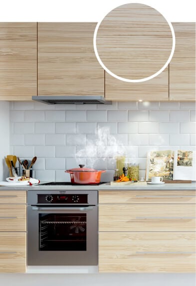 Honey colored bamboo kitchen cabinets with subway tile backsplash and grey countertops