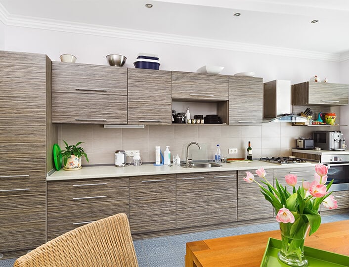 Open concept kitchen with beige quartz countertops and bamboo kitchen cabinets.