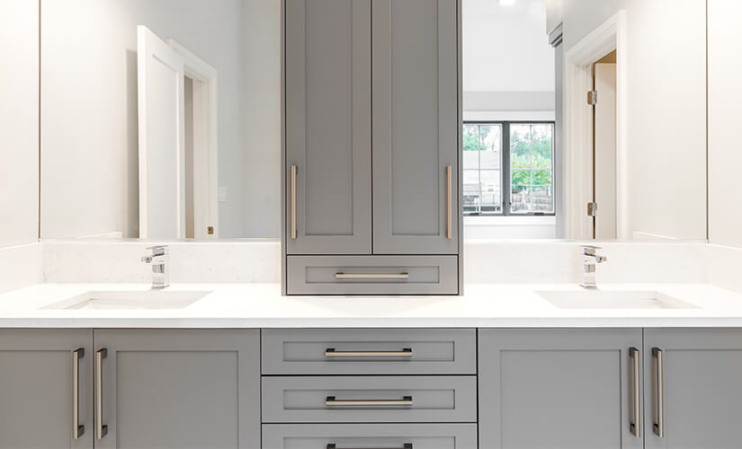 Gray bathroom vanity frameless cabinets and white countertop.