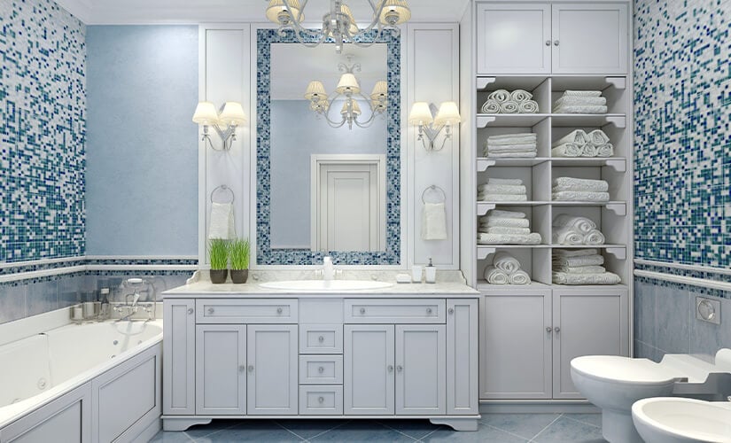 Traditional white bathroom vanity next to floor-to-ceiling linen closet with open shelves.