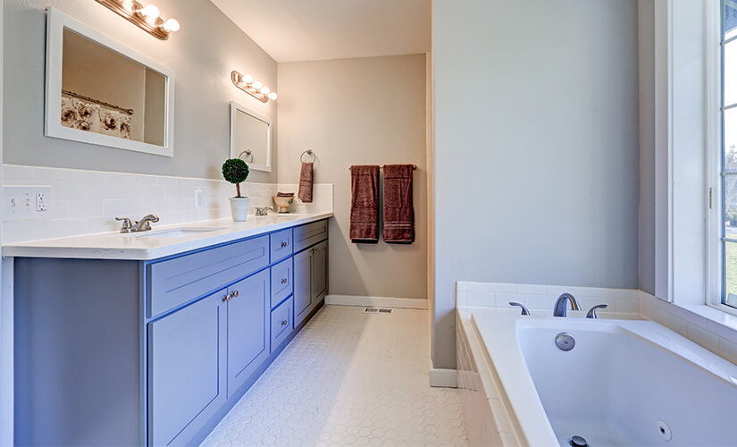 Blue bathroom vanity with white countertops.