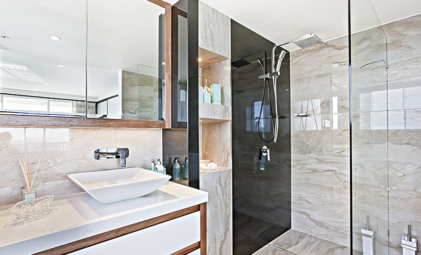 Bathroom with large glass shower and mirror cabinet over vanity.
