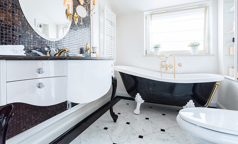Black and white bathroom with repurposed vintage vanity and matching clawfoot tub.