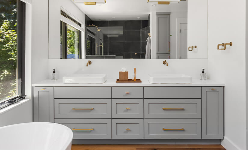 Gray bathroom vanity with gold hardware.