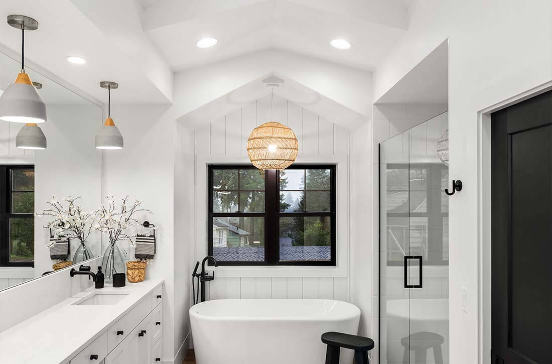 White bathroom with orb basket shade over bathtub.