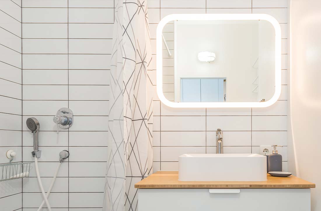 Small bathroom with LED lights in mirror.