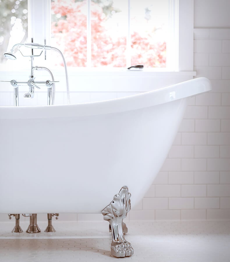 White free-standing clawfoot bathtub with chrome fixtures.