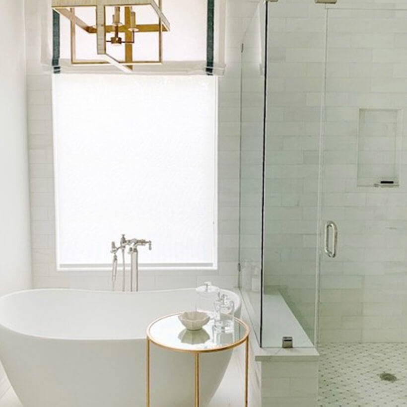 Newly renovated bathroom with white soaker tub and gold accents.