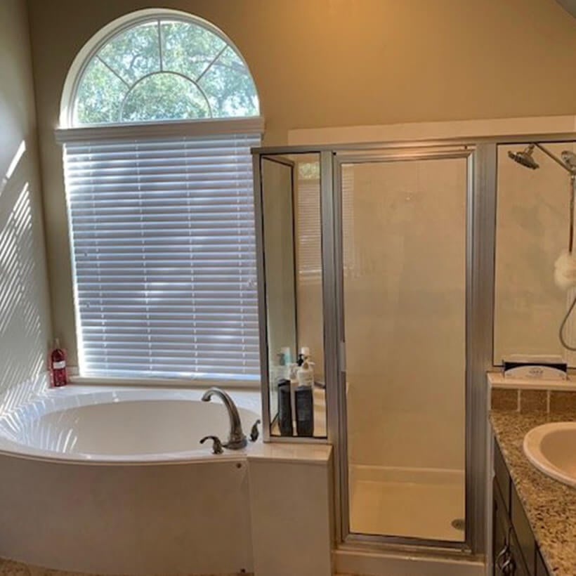 1990s bathroom with large shower enclosure and tub.