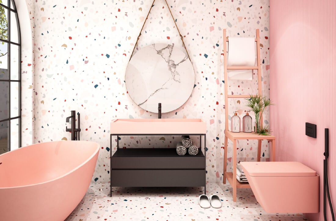 Bathroom with colorful terrazzo floor and wall and pink tub and toilet.
