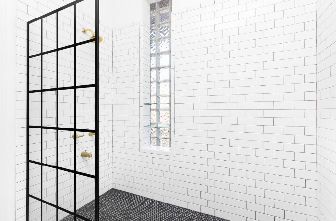 Bathroom with glass paneled shower divider.