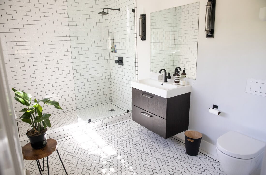 Bathroom with subway tile shower wall and small tile floors.