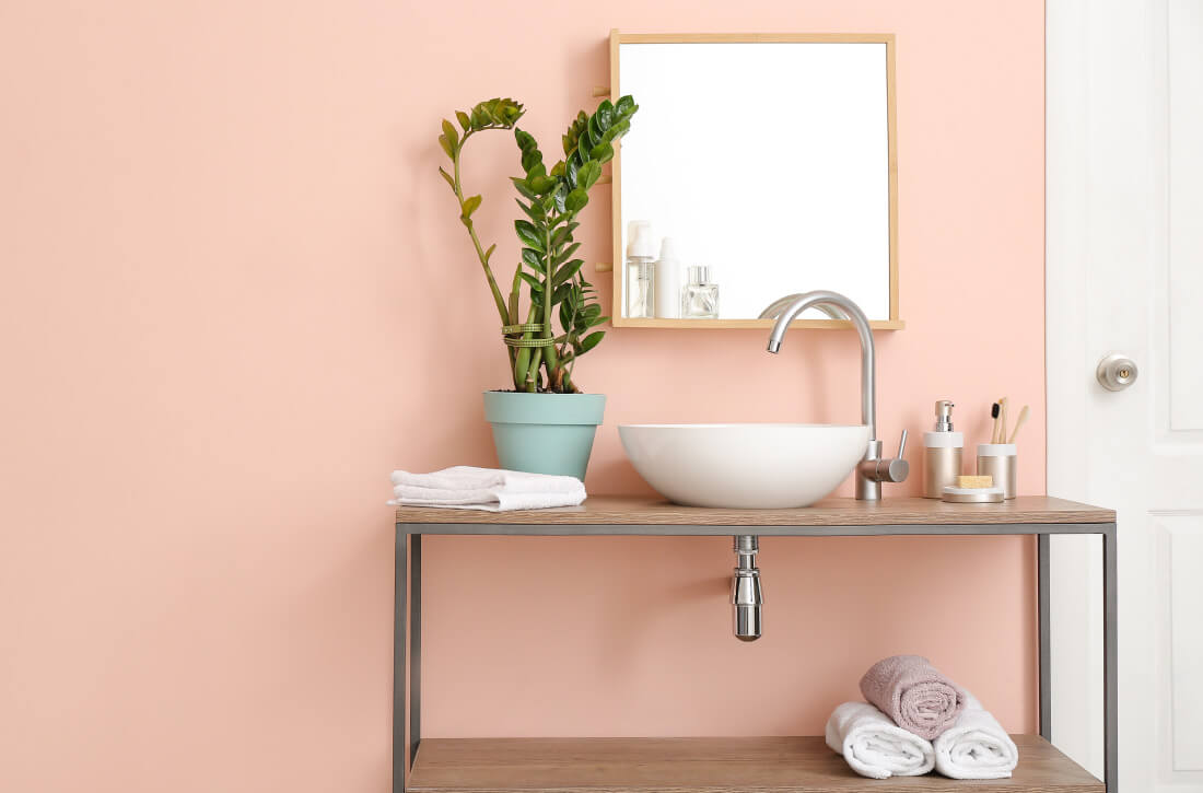 Bathroom with pink pastel painted walls.