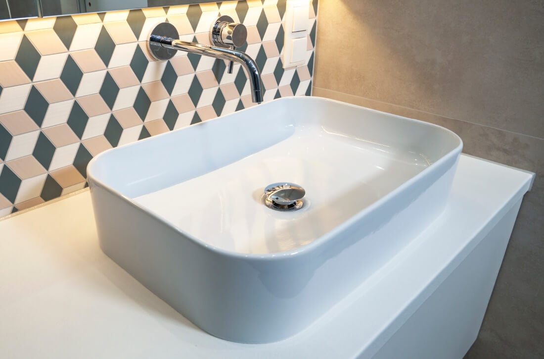 Bathroom sink with wall-mounted faucet.