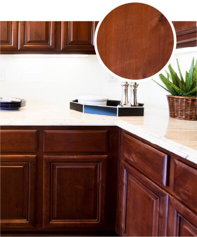 Birch kitchen cabinets with a rich brown stain and white countertops.