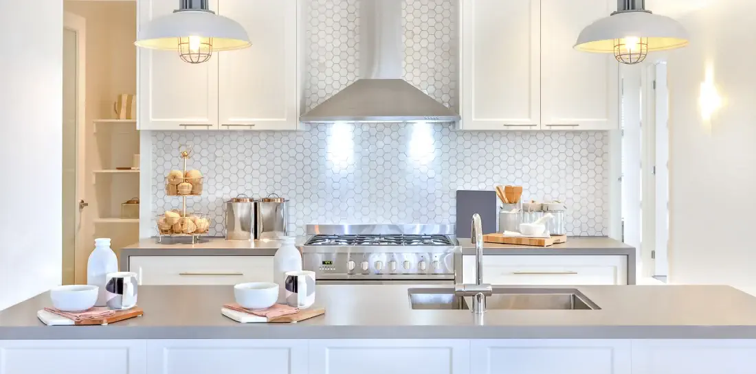 A kitchen backsplash uses white, hexagonal, budget-friendly tile.