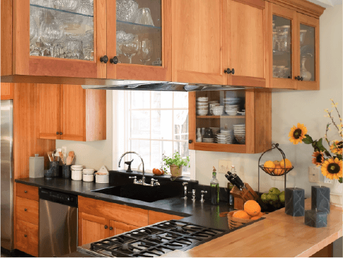 A kitchen with wooden cabinetry and black countertops.