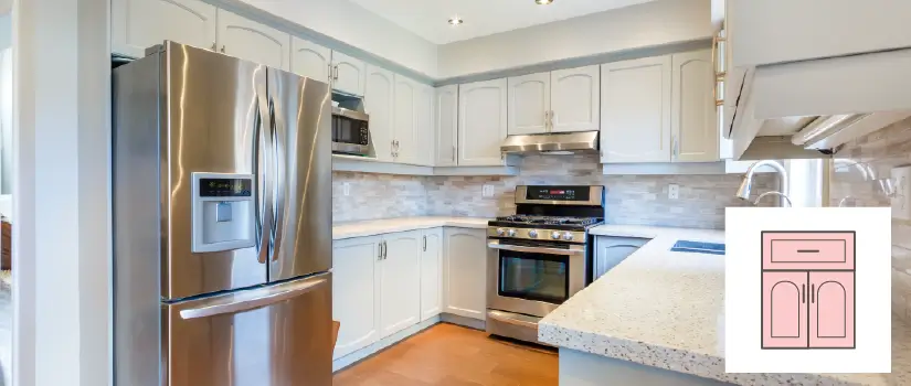 Kitchen with white arch-raised cabinets, granite countertop and beige tile backsplash.